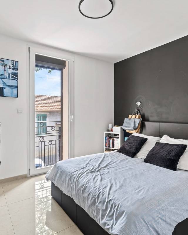 Chambre moderne avec mur noir, lit aux coussins turquoise et bureau près de la fenêtre