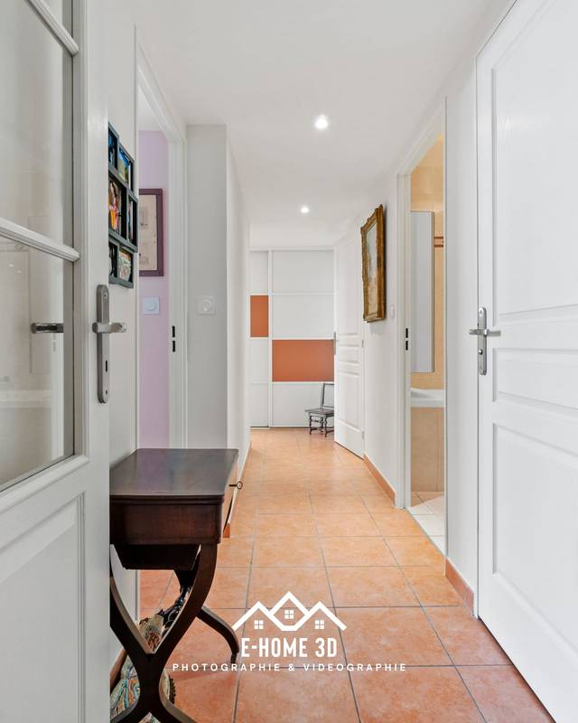 Couloir d'appartement ancien avec portes moulurées et sol en tomettes
