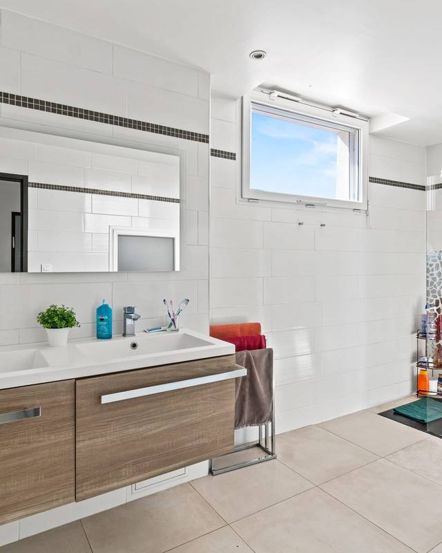 Salle d'eau blanche avec double vasque, grand miroir et douche à l'italienne