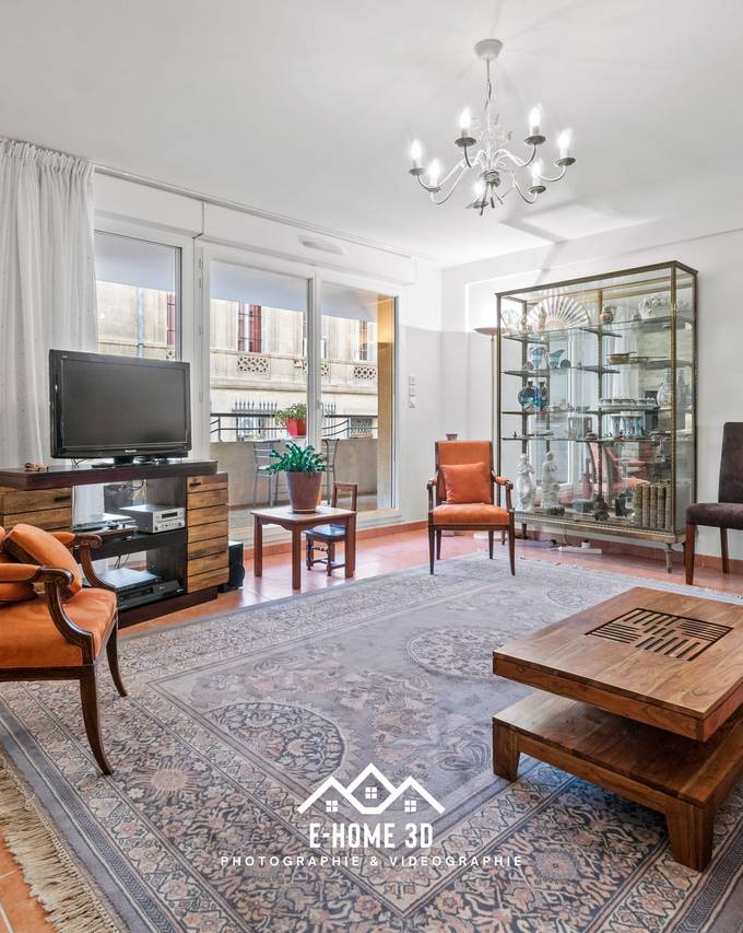 Salon avec mur en pierre, tapis oriental et fauteuils en cuir