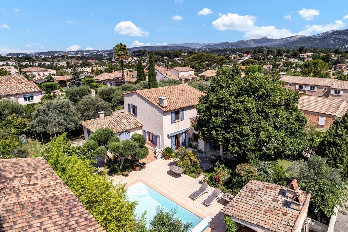 Vue aérienne oblique d'une villa provençale avec piscine, oliviers et collines en fond